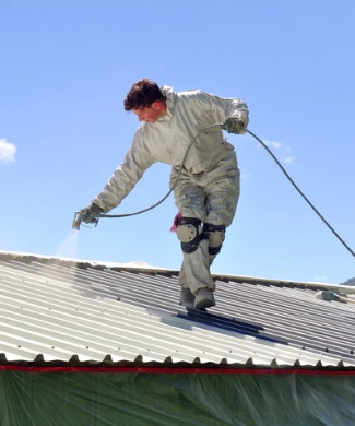 The picture shows how a worker waterproofs a roof with a sprinkler
